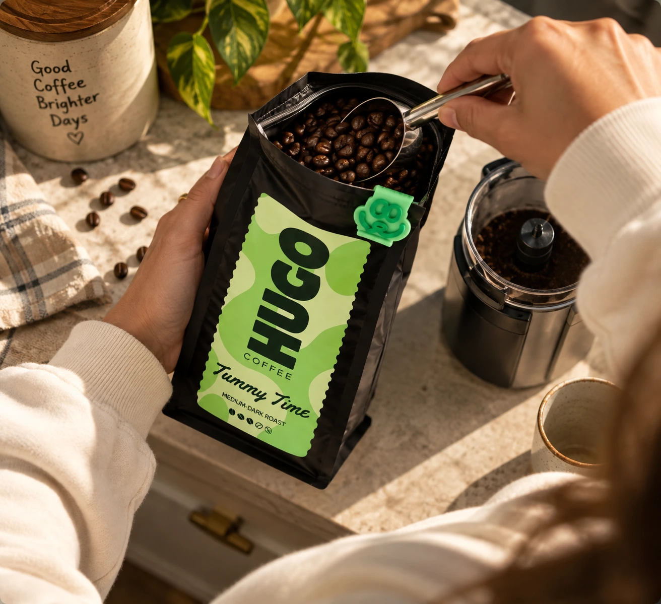 Scooping whole coffee beans from a freshly opened bag of Tummy Time